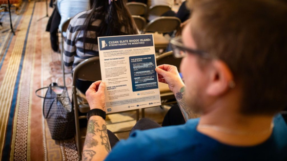 Person holding RBIJ's Clean Slate Rhode Island Info Sheet